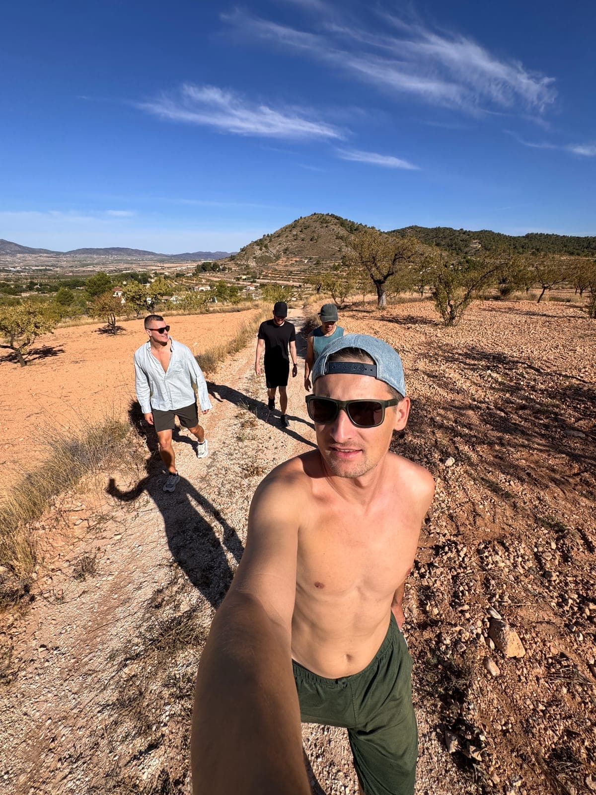 People walking a dirt path through dry hills